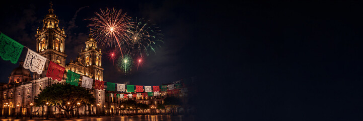 Naklejka premium Night view of illuminated cathedral with fireworks and papel picado garland. Mexican Independence Day celebration with colorful decoration and festive national holiday concept Banner with copy space