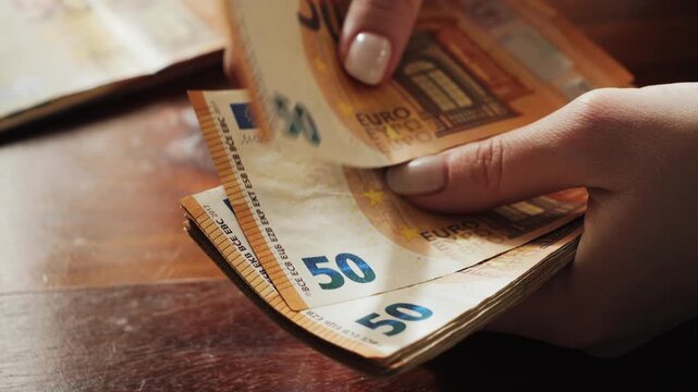 Hands of a woman counting many 50-euro bills. Woman counts banknotes salary or unemployment benefit. High quality 4k footage