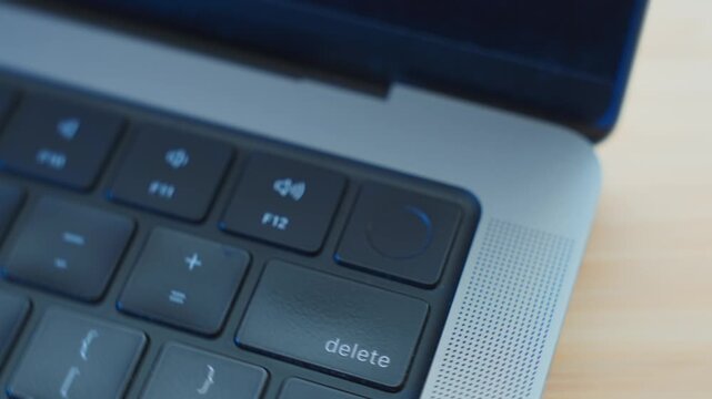 Close up on finger pressing againt fingerprint reader on laptop computer. Authorizing or accessing system by touching scanner. Identifying user confirming process. Hacker or spy access private data