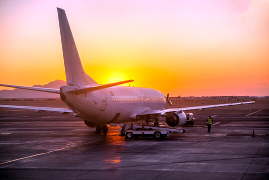 A passenger plane is at the airport at dawn.