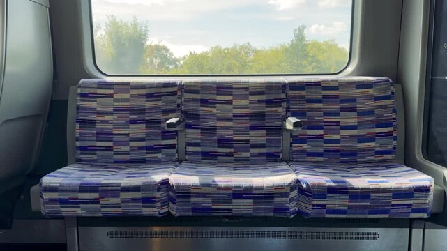 Empty Patterned Train Seats by a Window in Daylight