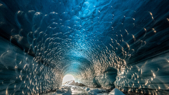 Glacier blue ice cave interior with textured frozen ice ceiling