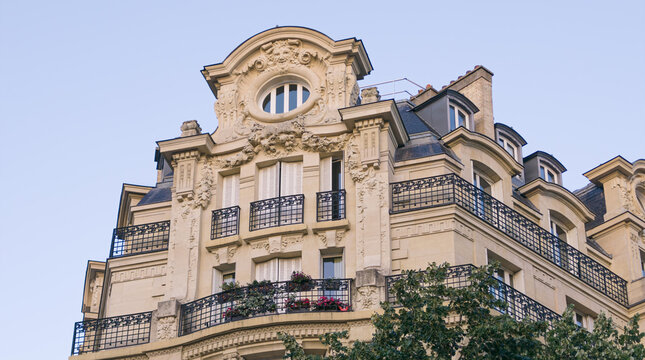 Ornate Haussmann building featuring balconies and a decorated facade against a clear sky