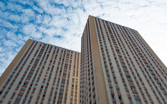 Les Olympiades residential towers rising against a blue sky with clouds, showing urban architecture