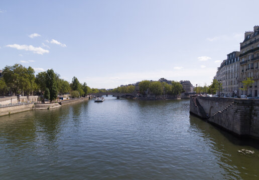 Seine river flowing past historic buildings and bridges in Paris, France
