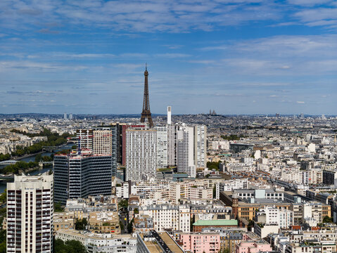Paris cityscape with iconic landmarks, buildings, and the Seine River under a blue sky