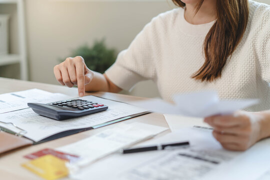 person using calculator calculating tax refund on the table
