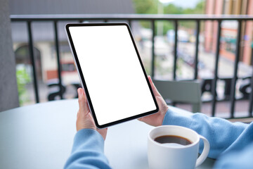 Mockup image of a woman holding digital tablet with blank white desktop screen in cafe © Farknot Architect