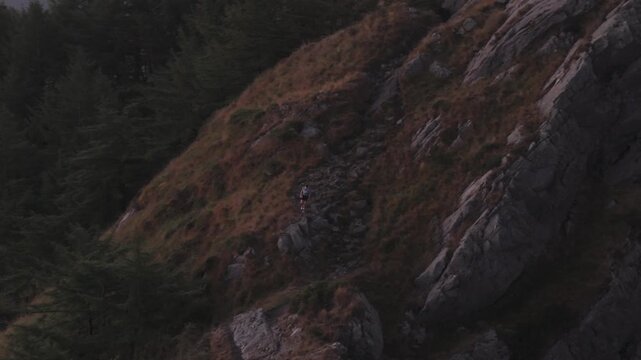 Man hiking and running on the top of the mountains at sunset time, at the Basque Country.