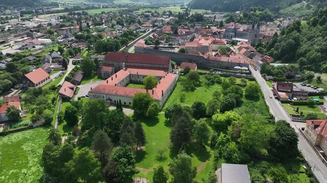 Summer drone footage showing medieval Friesach, old fortified walls, rooftops, towers, hills, serene atmosphere, warm daylight, gentle cinematic motion