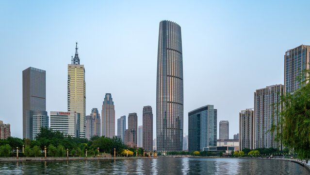 Modern Urban Skyline Along Calm Waterfront Under Clear Sky