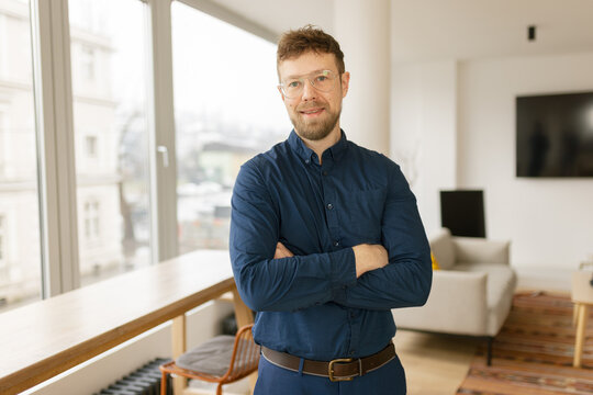 Smiling business man looks at the camera at home