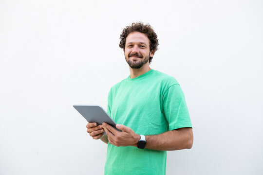 Smiling man holds a digital tablet on a white background