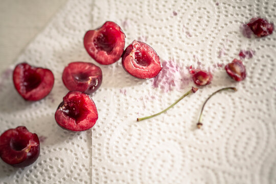 Halved sweet cherries on kitchen towel, close up
