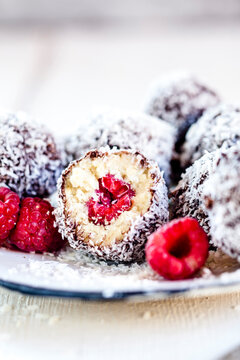 Lamington bliss balls with cashews, filled with raspberries, dark chocolate and coconut flakes