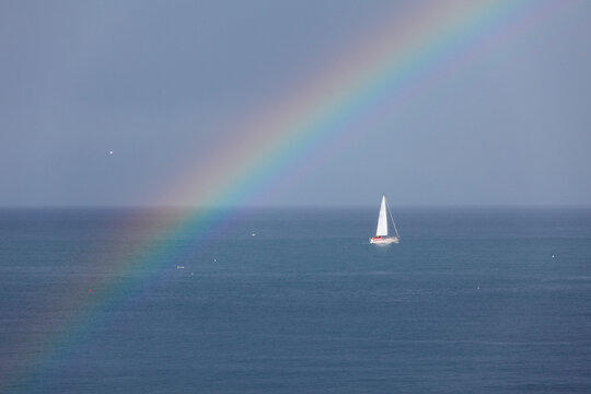 Ireland, Leinster, County Fingal, View of boat in sea with rainbow