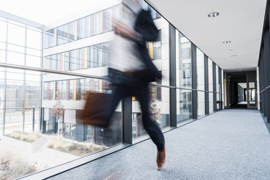 Businessman running in corridor of an office building