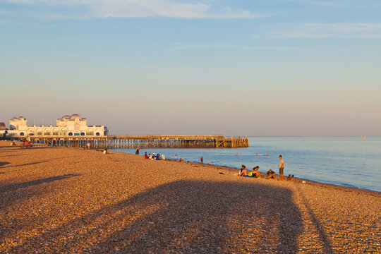 Sunlight illuminates South Parade Pier on the beach in Portsmouth