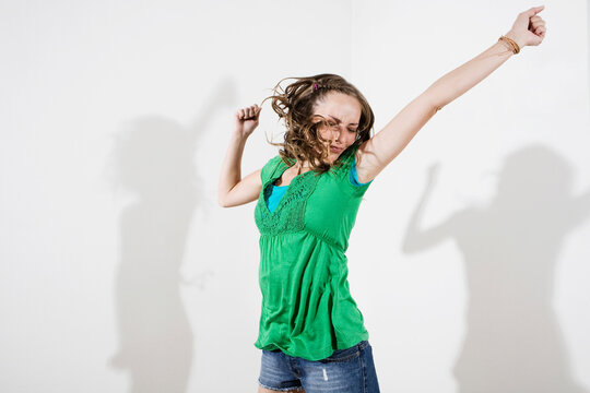 Germany, Berlin, Young woman dancing, eyes closed