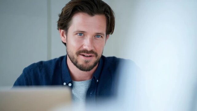 Close-up video call angle of a man in casual attire, engaging and relaxed style.