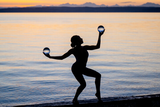 Silhouette of Hispanic woman balancing with spherical objects