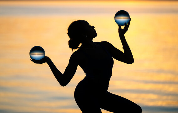 Hispanic woman balancing two crystal balls