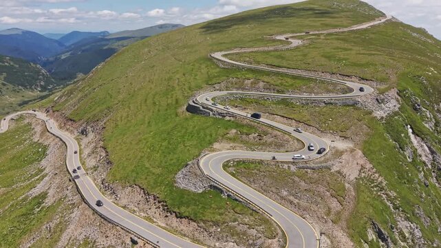 Cars Winding Across Exposed Mountain Road