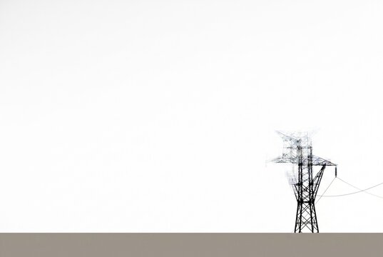 Graphic high contrast monochrome silhouette of an industrial power transmission tower on pure white background