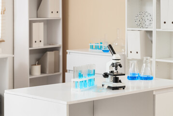 Scientific research and medical innovation, microscope with test tubes and blue liquid in a modern...