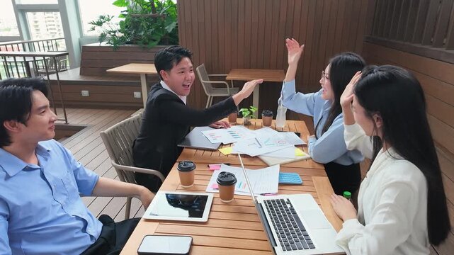 Asian Business Team Celebrating Success with High Fives on Office Terrace
