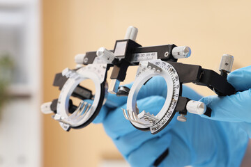 Eye examination and vision care, optometrist holding trial frame for prescription glasses in...