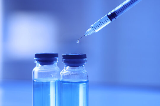 Vaccination and immunization campaign, medical syringe with vaccine vials for healthcare research and disease prevention in a clinical laboratory setting
