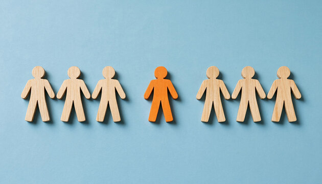 Wooden figurines in line with one orange figure standing out representing individuality concept on blue background