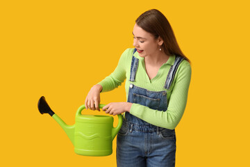Beautiful young woman with watering can on yellow background © Pixel-Shot