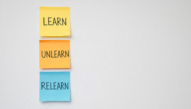 Learn unlearn relearn concept on colorful sticky notes against white background for personal growth and education