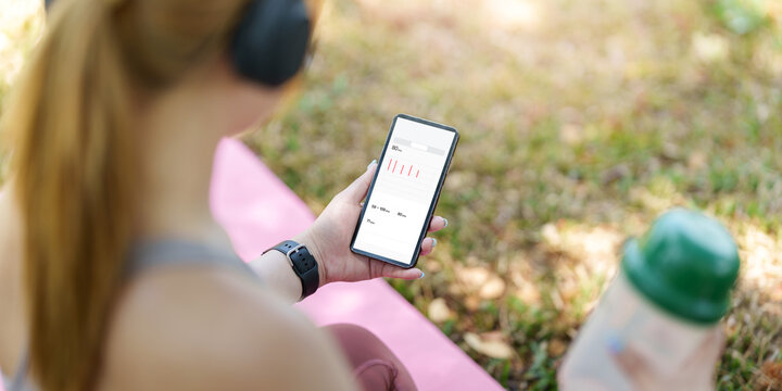 Smartphone fitness tracking app held outdoors after workout for digital health monitor