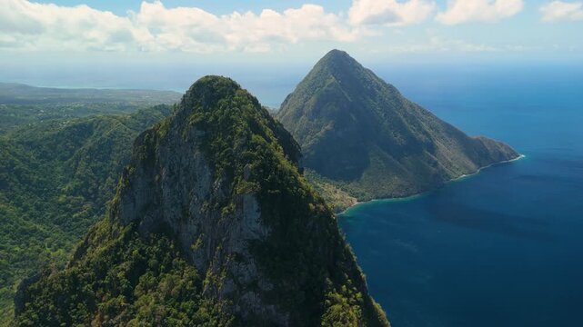 High altitude view follows ridge between Petit and Gros Piton toward distant coastline and deep blue sea St Lucia