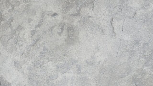 Old grey concrete floor with cracks and natural stains. Industrial loft grey cement floor texture backdrop. Raw grey concrete surface with distressed texture, perfect for modern design backdrops. 