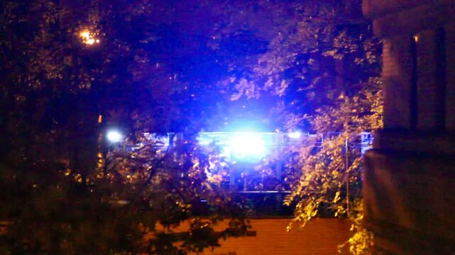 Luz azul de polic&iacute;a y ambulancia destello intermitentes y parpadear luces estrobosc&oacute;pica de emergencia y urgencia deslumbrar sirena en edificio y &aacute;rbol con ramas y hojas