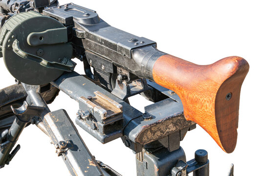 Close-up view of disassembled light machine gun, featuring dark metallic body and wooden stock, mounted on bipod with visible wear and exposed internal components, highlighted by even lighting in