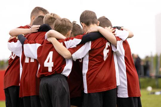 Youth Football Team in Maroon and White Uniforms Gathering in Tight Pre-Match Huddle - Children Soccer Team Unity and Motivation Concept