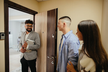 Real estate agent meeting young couple for apartment showing