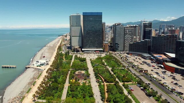Amazing aerial view of the lech and maria kaczynski park in batumi, georgia, featuring modern architecture, lush green spaces, and the beautiful black sea coastline on a sunny summer day