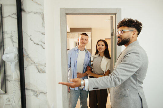 Real estate agent showing new property to young couple
