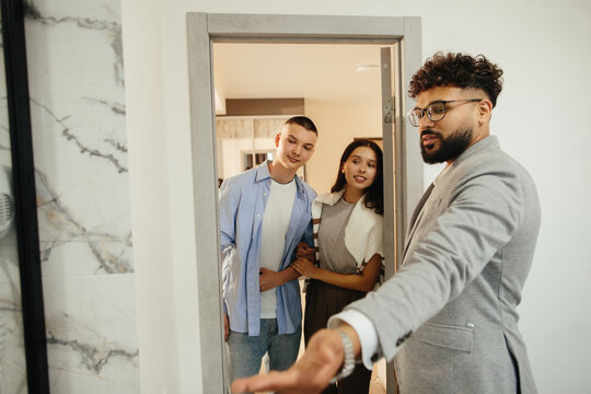 Real estate agent showing young couple apartment