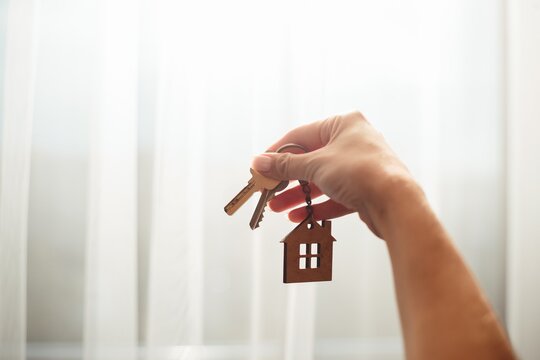 Hand holding house keys new home concept