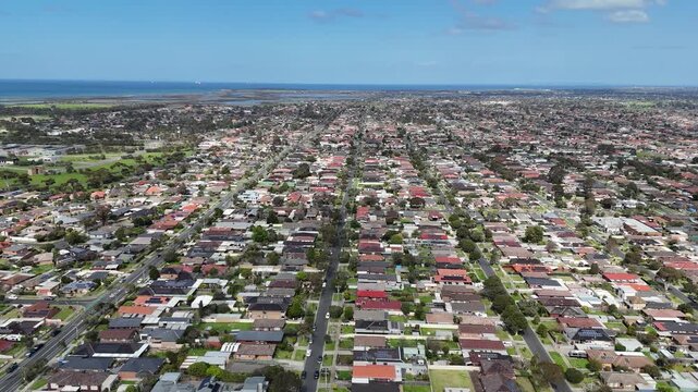 Expansive high-angle aerial view of houses, a neatly planned grid layout with straight, long residential streets stretching towards the coastline&nbsp;in Altona Meadows, Melbourne, Victoria, Australia 