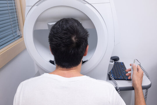 Man undergoing a visual field test at an eye care clinic, checking for eye conditions