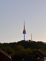 Obraz premium N Seoul Tower viewed above traditional Korean tiled roofs, blending modern landmark and heritage