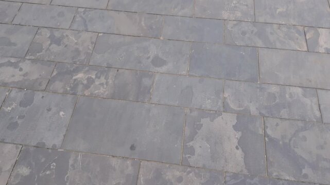 Camera Moves Over a Weathered Grey Slate Tiled Pavement, Urban Background Footage
